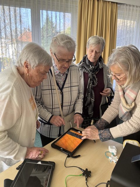 Senioren stehen um ein Tablet